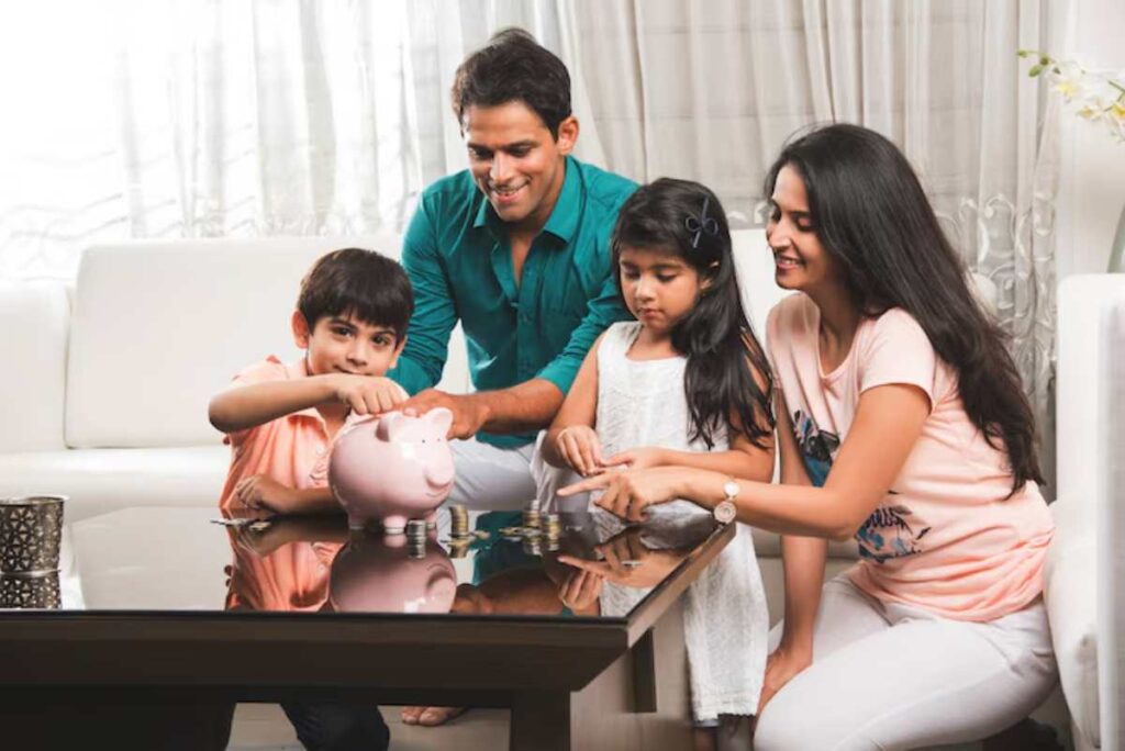 A family sitting around a table, joyfully counting coins and interacting with a pink piggy bank, in a bright, cozy living room.