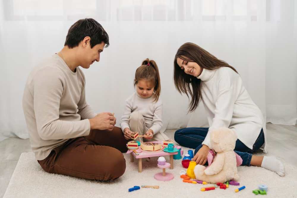 A family plays together on a soft rug, engaging with colorful toys on a small table, surrounded by a warm, inviting atmosphere.