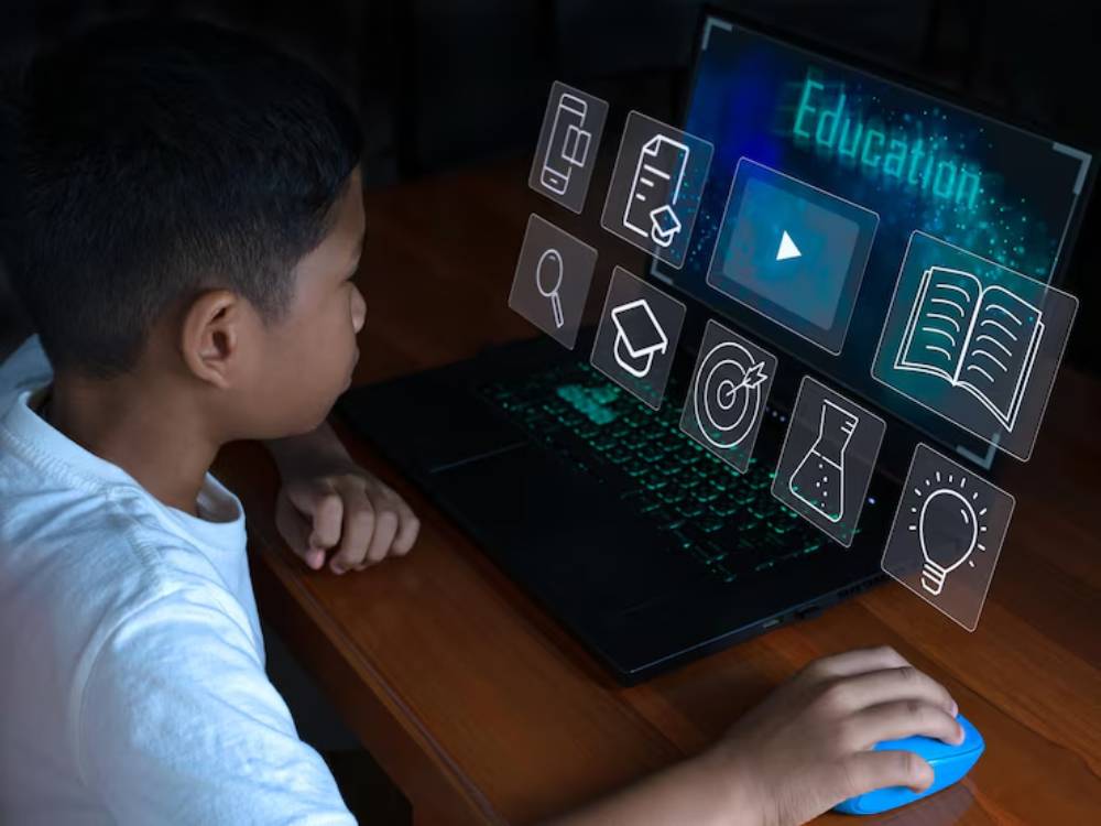A child interacts with a laptop displaying educational icons, focusing on learning and digital engagement.