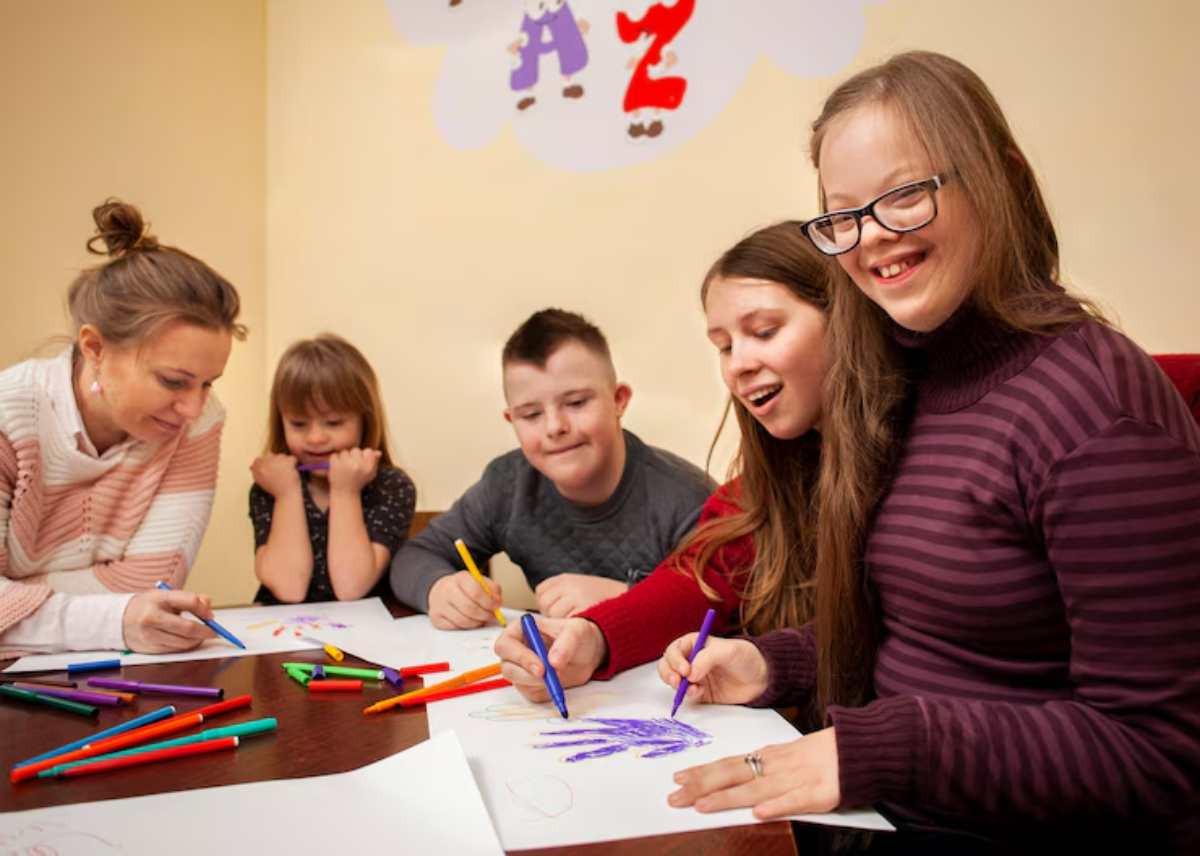 A group of children and adults engage in a coloring activity, surrounded by colorful markers and completed drawings on a table.