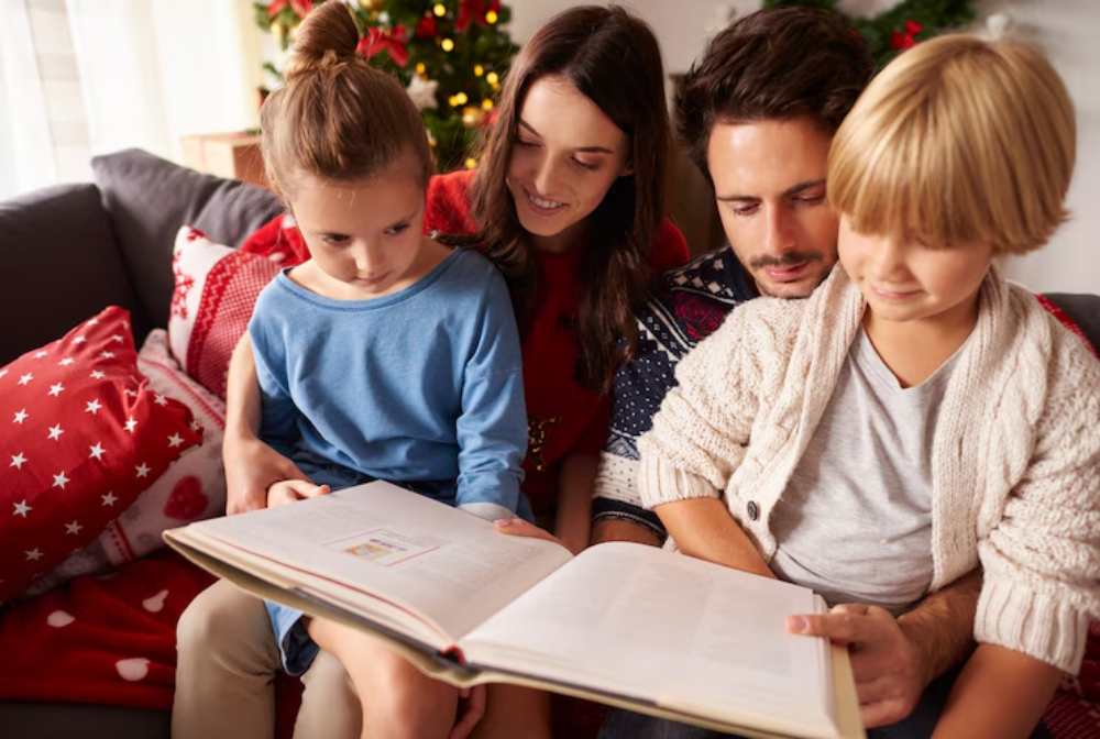 A group of children cozying up on a sofa, reading a book together, surrounded by festive decorations and plush pillows.